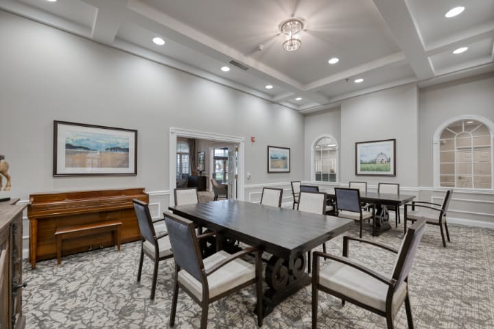 Elegant dining room with a large table, surrounded by chairs and decorated with artwork.