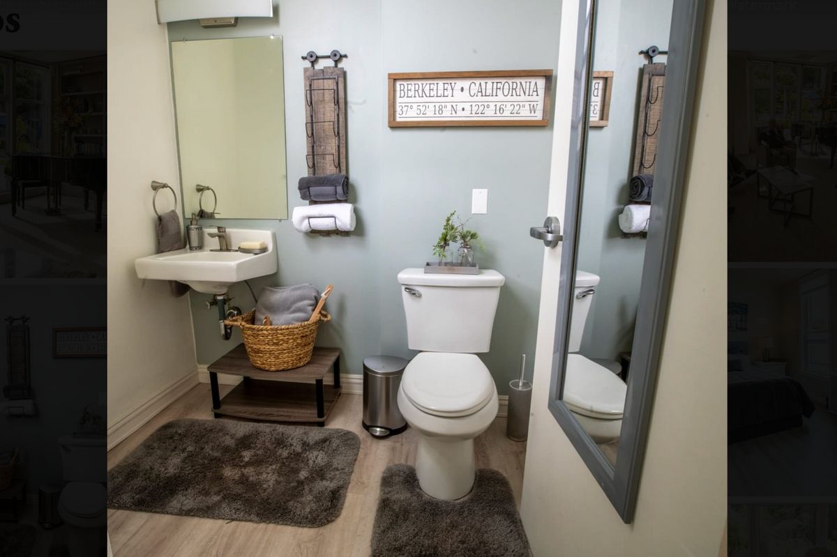 A neatly organized bathroom with a toilet, sink, and decorative accents.