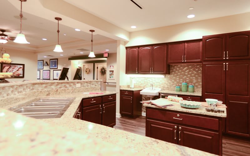 A modern kitchen with dark wood cabinets and sleek countertops.