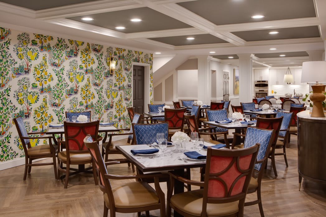 A beautifully decorated restaurant dining room with elegant furniture and colorful wallpaper.