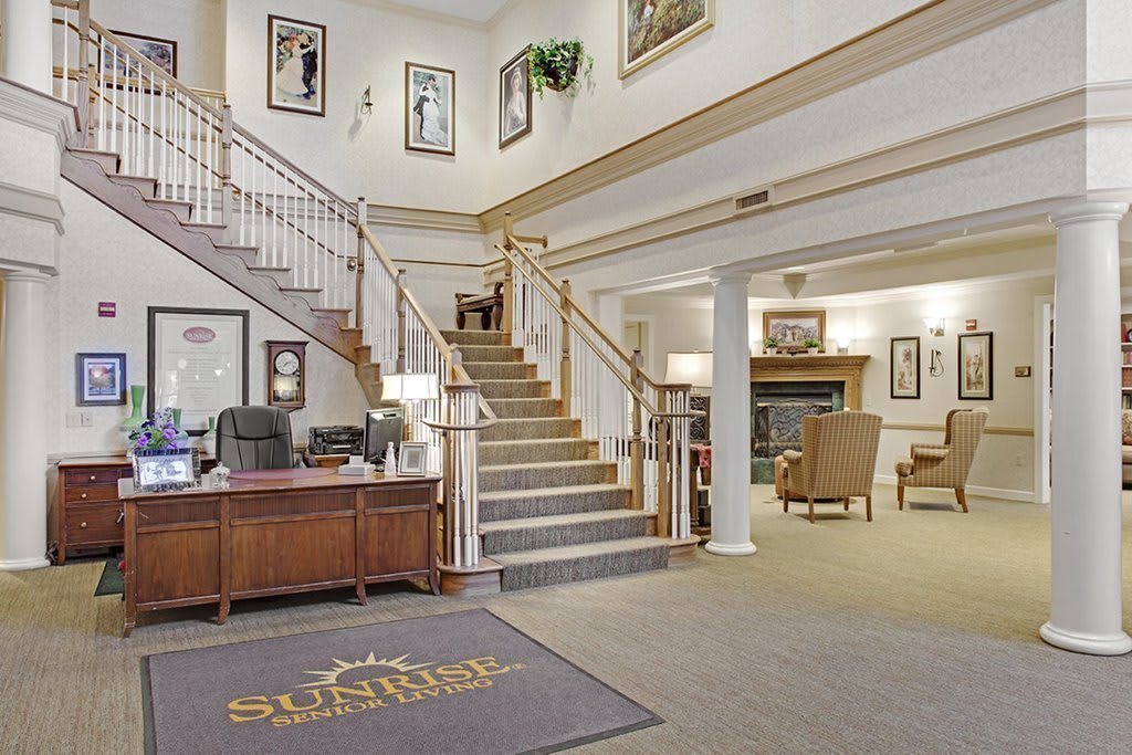 Elegant lobby with a central staircase and reception desk.