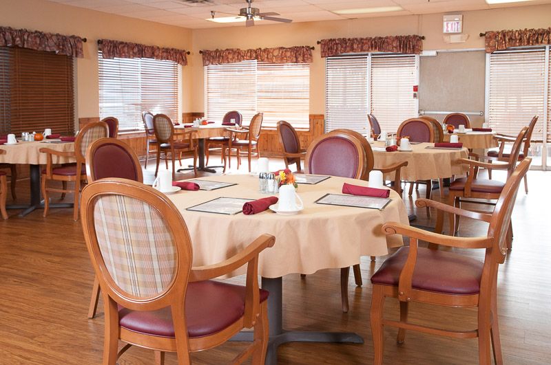 An empty dining room with neatly arranged tables and chairs, ready for guests.