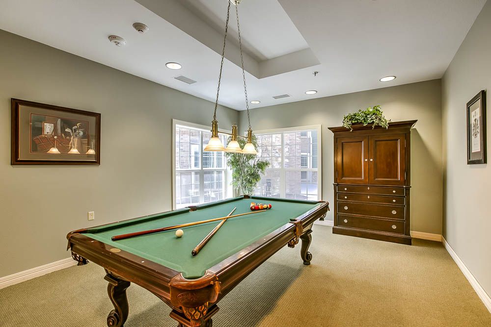 A cozy billiard room with a pool table and elegant lighting.