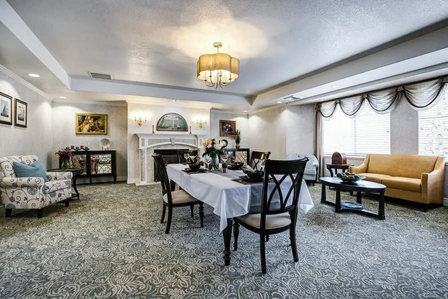 A beautifully decorated dining room with a set table and elegant lighting.