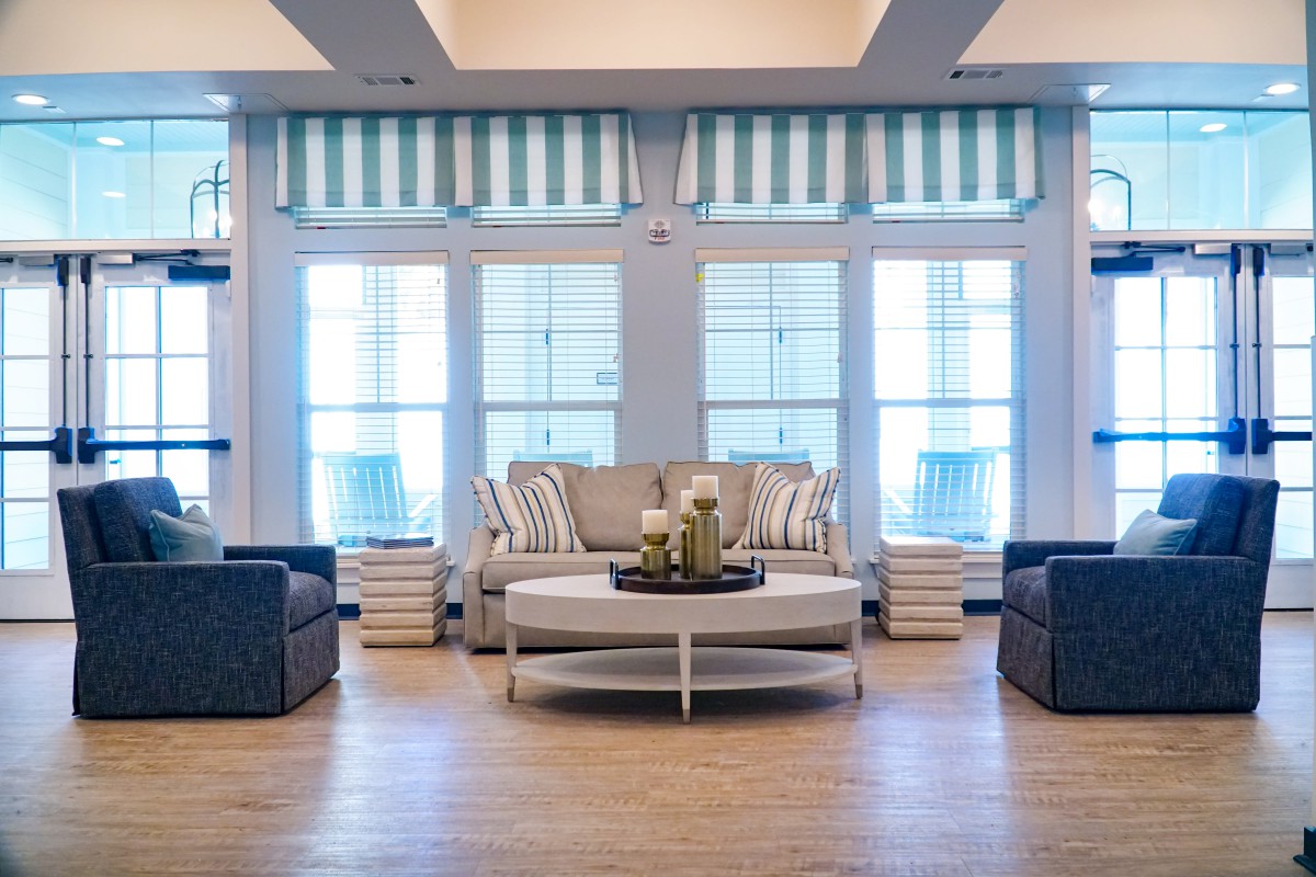 A stylish living room with modern furniture and striped drapes.
