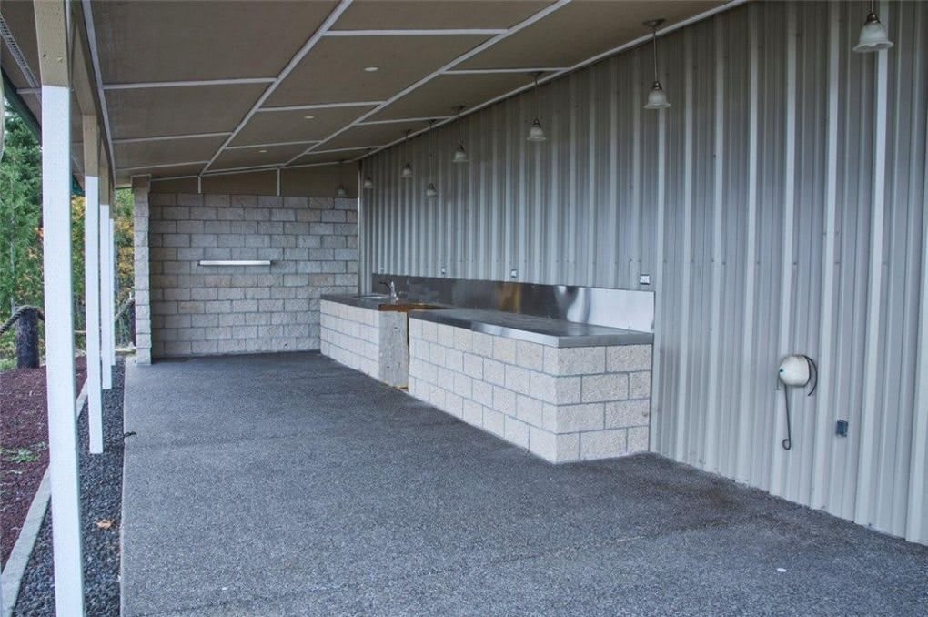 Outdoor kitchen area with concrete counters and metal siding.