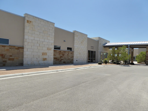A modern commercial building with a clear blue sky above.
