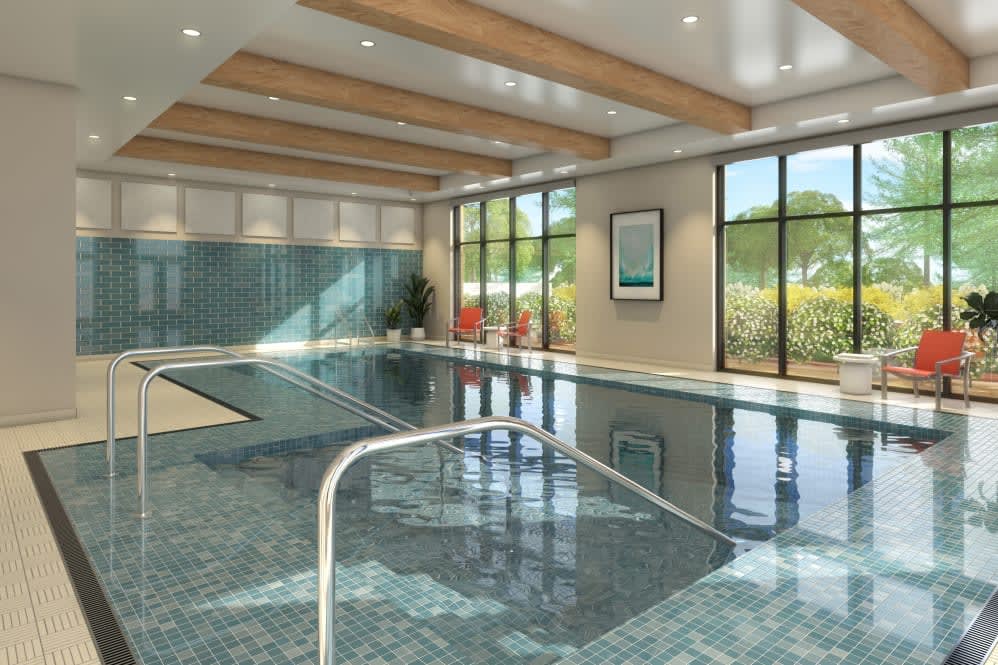 A luxurious indoor swimming pool bathed in natural light.