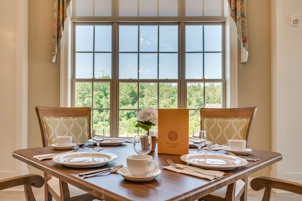 A beautifully set dining table with a scenic view through large windows.