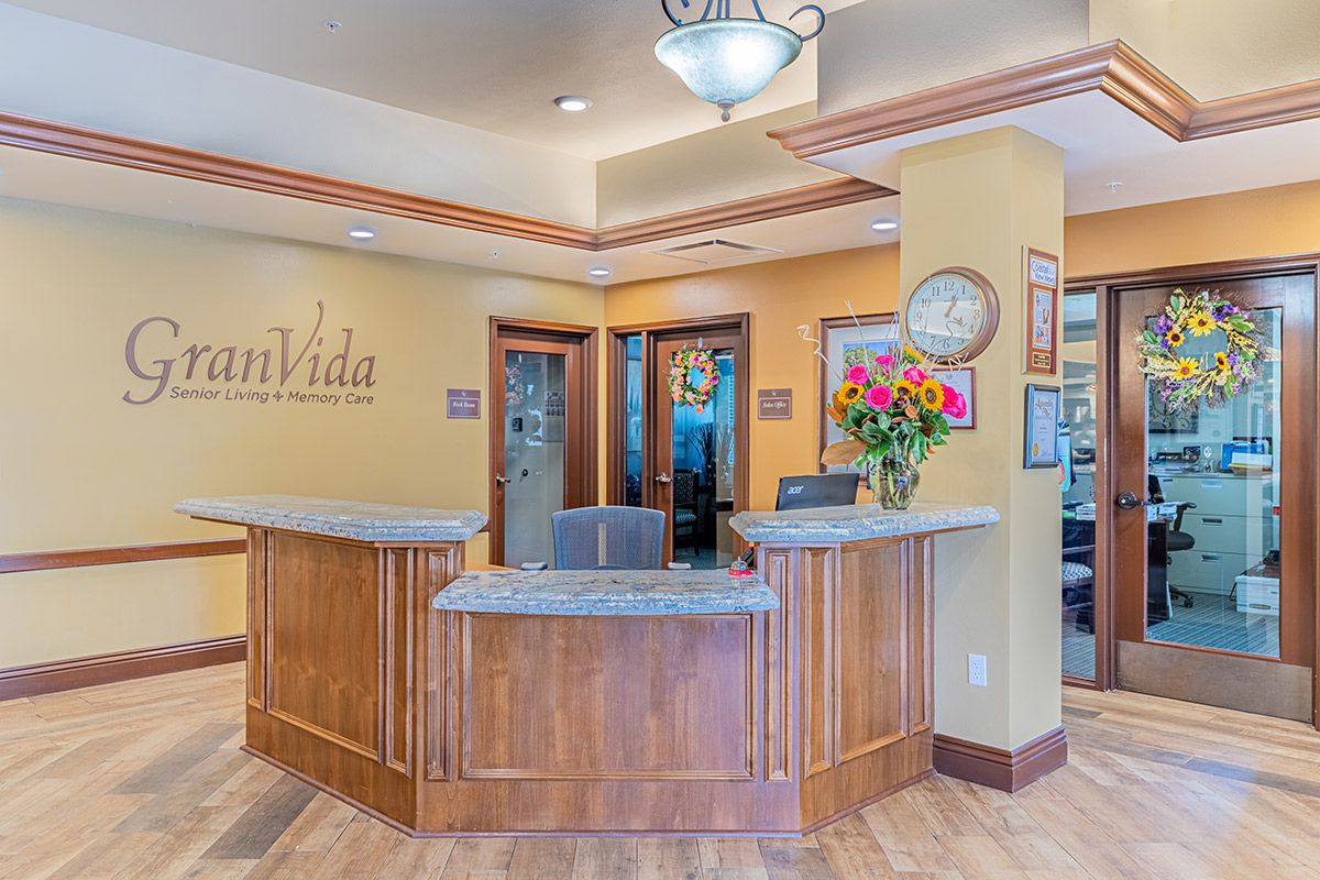 A welcoming reception area with a wooden desk and floral arrangement.