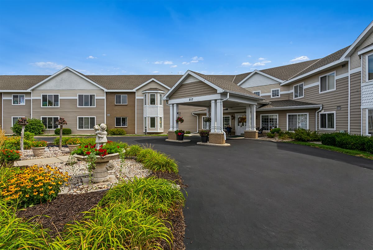 A modern residential building with a landscaped entrance and driveway.