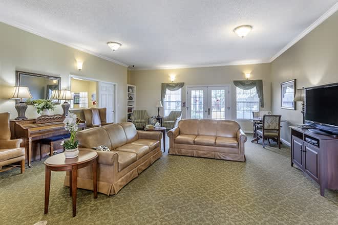 A spacious living room with traditional decor, featuring two leather sofas and a coffee table.