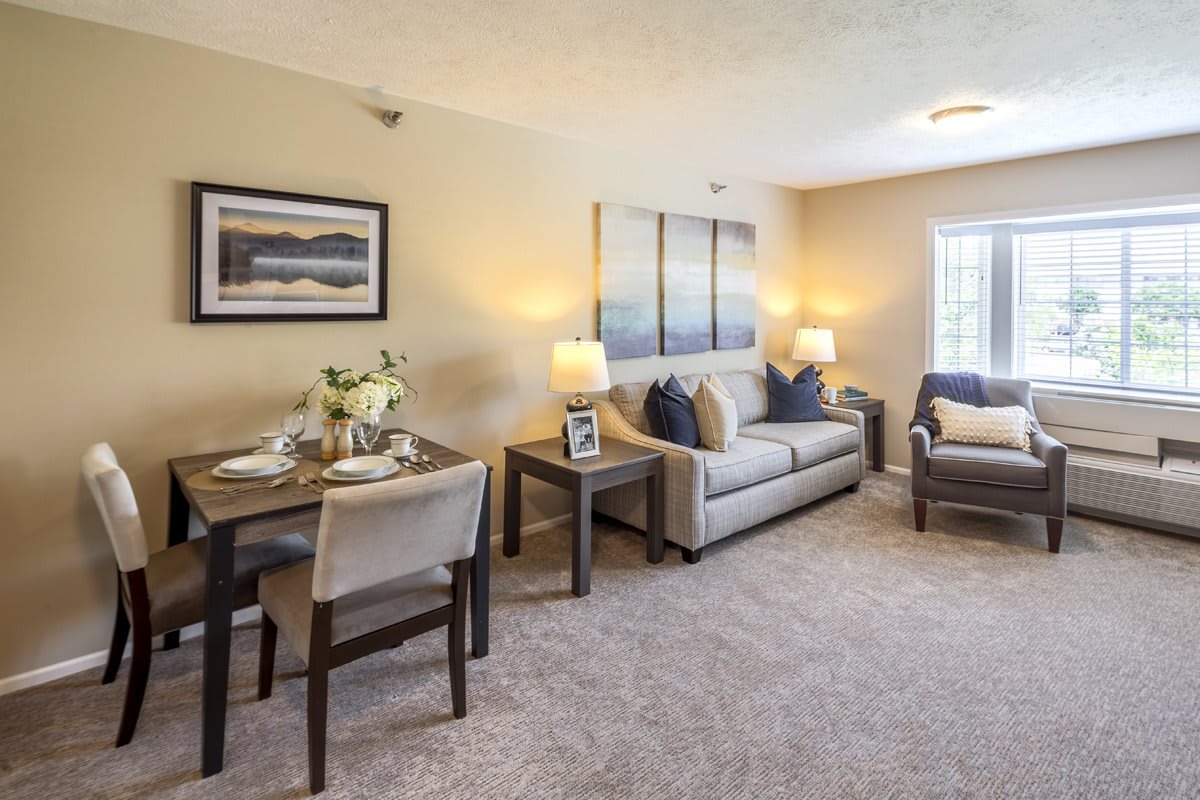 A cozy living room with a comfortable sofa, dining table, and tasteful decor.