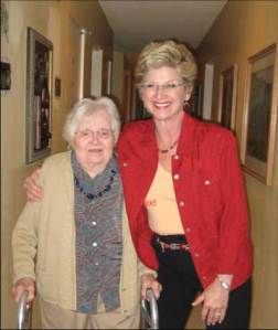 Two women standing together in a hallway, showing companionship and support.
