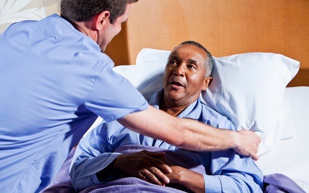 A nurse providing care to a patient in a hospital bed.