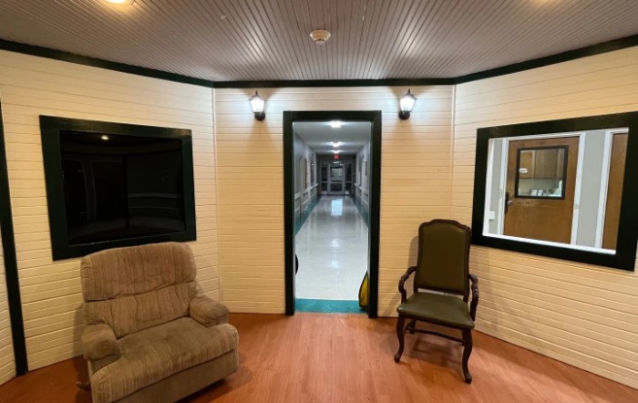 A cozy interior space featuring comfortable seating, warm lighting, and a long hallway.