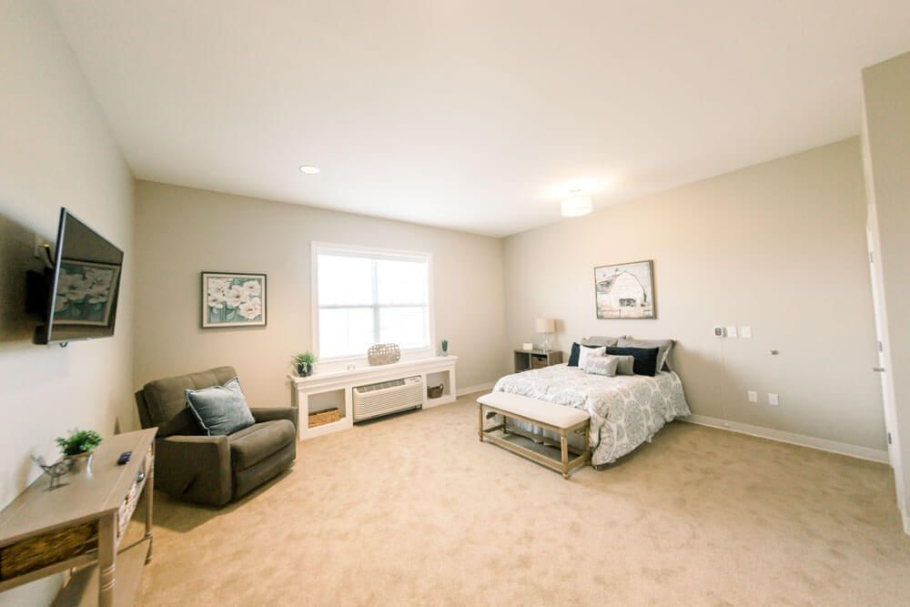 A spacious and minimalist bedroom with modern decor and furnishings.