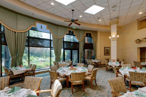 A stylish dining area with natural light, featuring elegantly set tables and comfortable seating.
