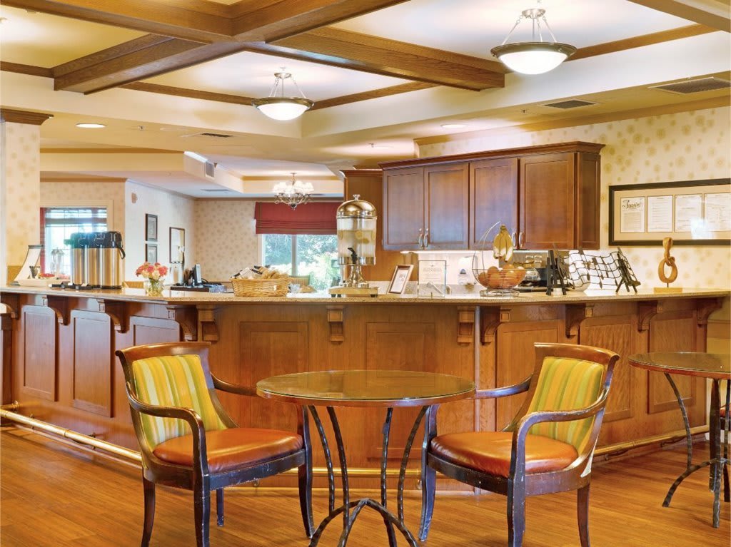A cozy kitchen and dining area featuring wooden cabinetry, a coffee bar, and seating.