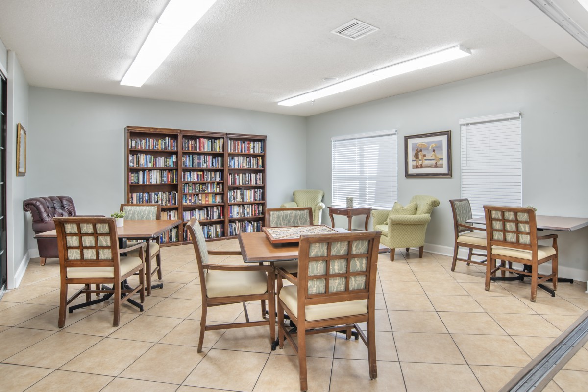 A bright and inviting reading room with bookshelves, tables, and chairs.