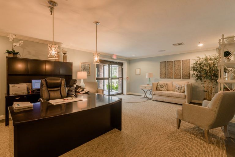 A modern, warmly-lit office reception area with a desk and comfortable seating.