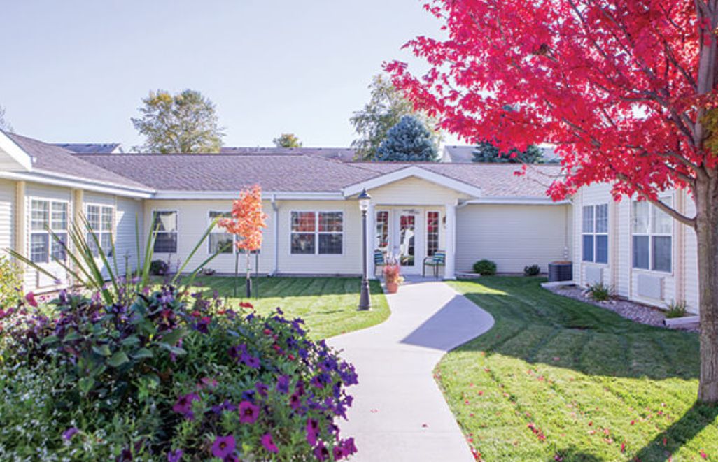 A charming house with a well-maintained garden and colorful autumn foliage.
