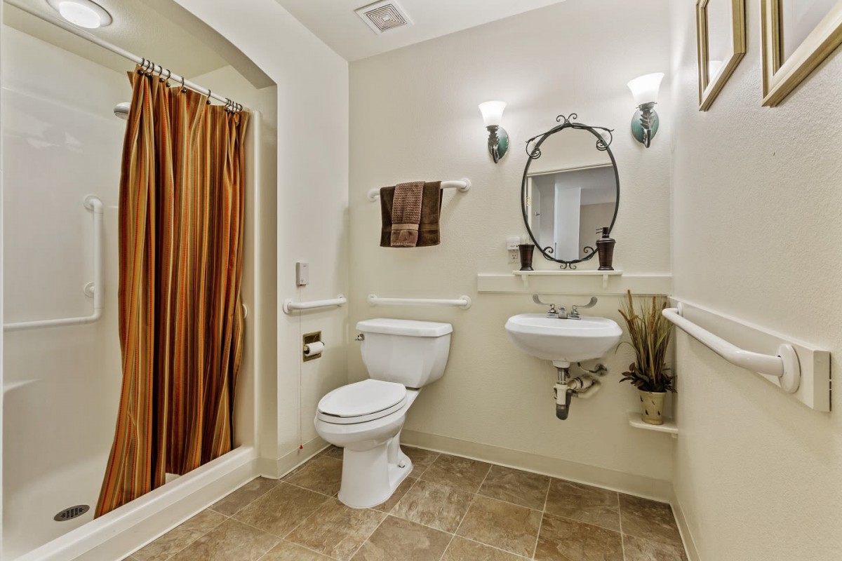 A clean and well-decorated bathroom with a toilet, sink, and shower.