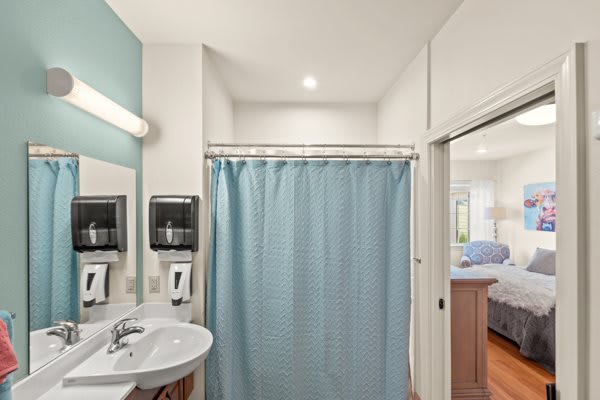 A clean and modern bathroom with a blue shower curtain and essential amenities.