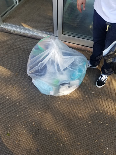 A garbage bag filled with items, waiting to be disposed of properly.