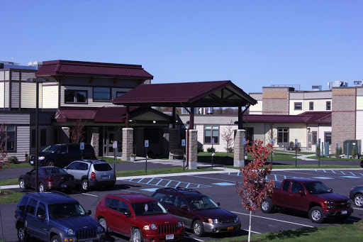 A modern building with a parking lot, showcasing contemporary architecture in a clear blue sky.