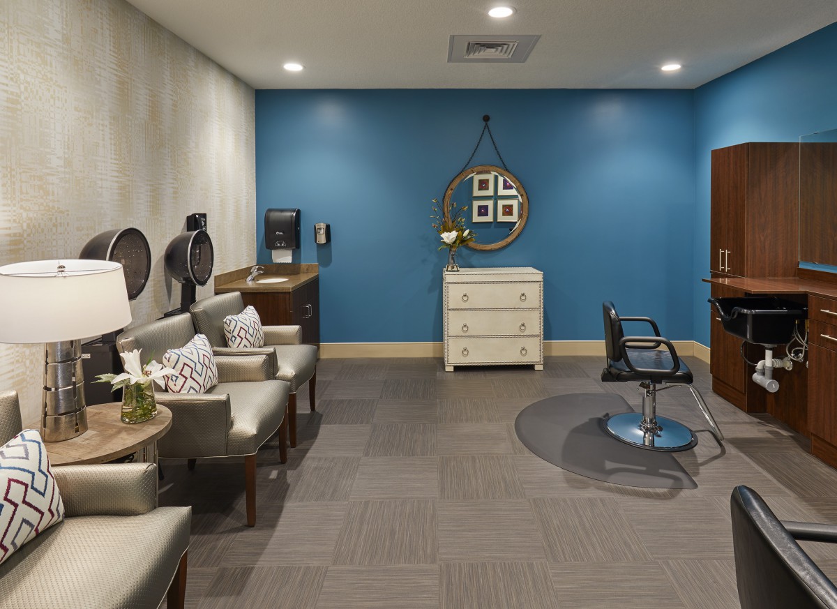 A modern salon interior featuring a waiting area and a hairdressing station.