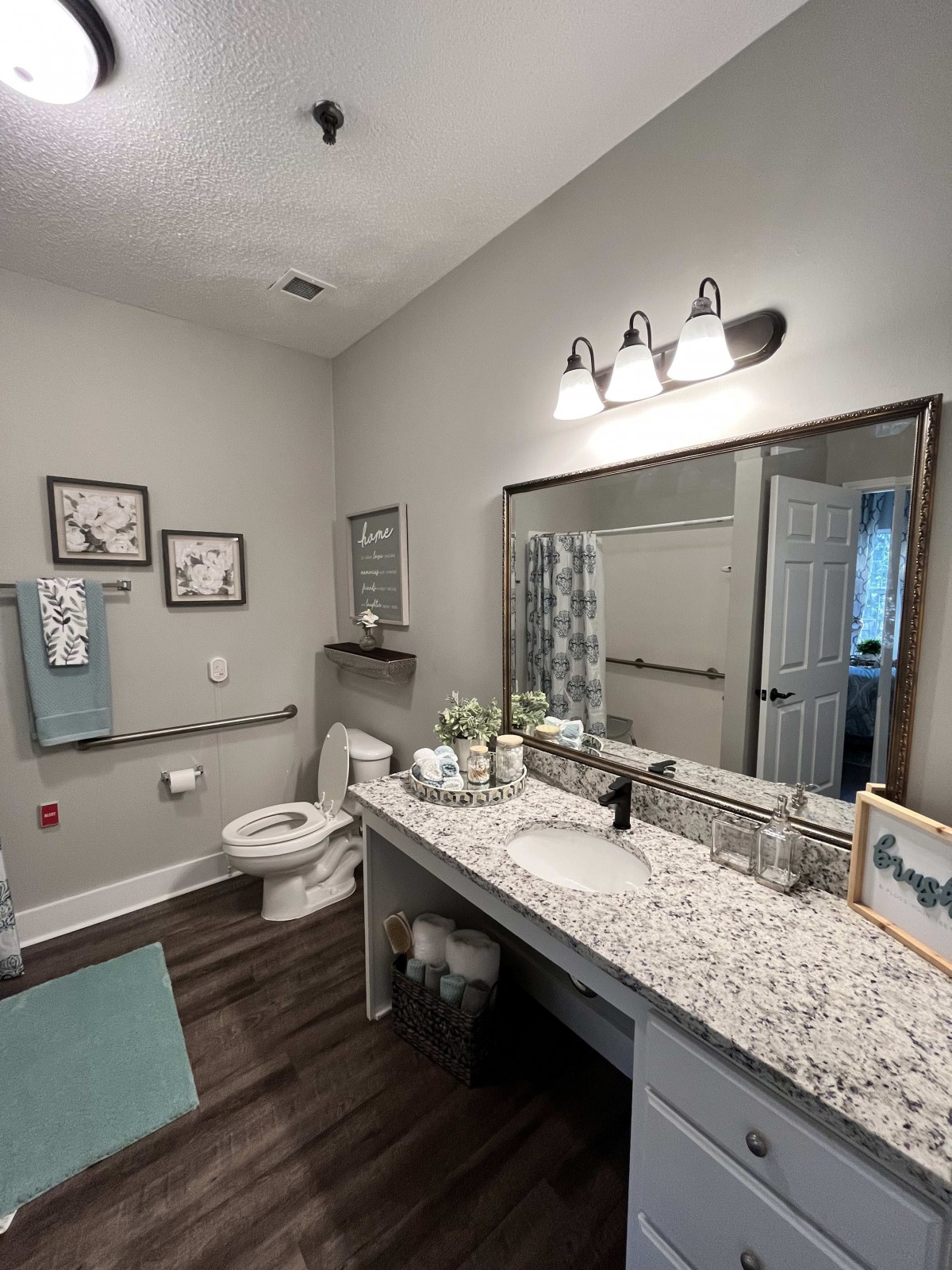A modern bathroom featuring a large mirror, sink, and decor elements.