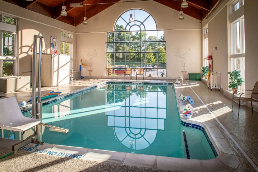 A bright indoor swimming pool with large windows allowing natural light to fill the space.