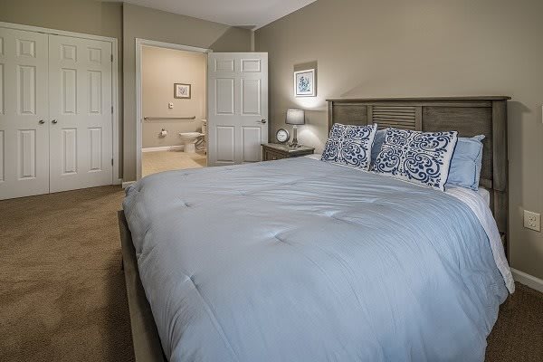 A modern bedroom with a large bed and neutral decor.