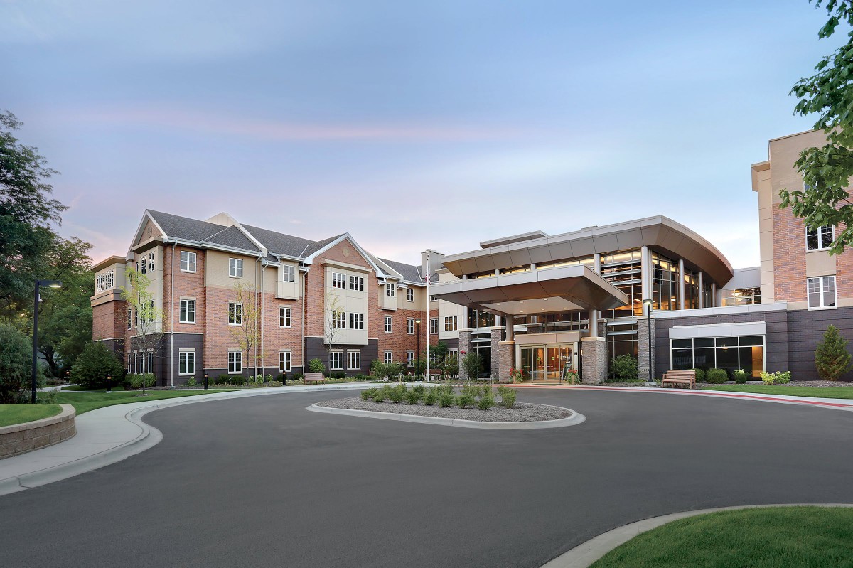 A modern residential building with a spacious driveway.