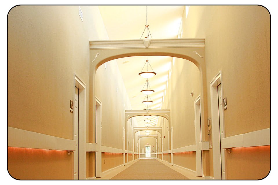 A symmetrical hallway with elegant lighting fixtures and archways.