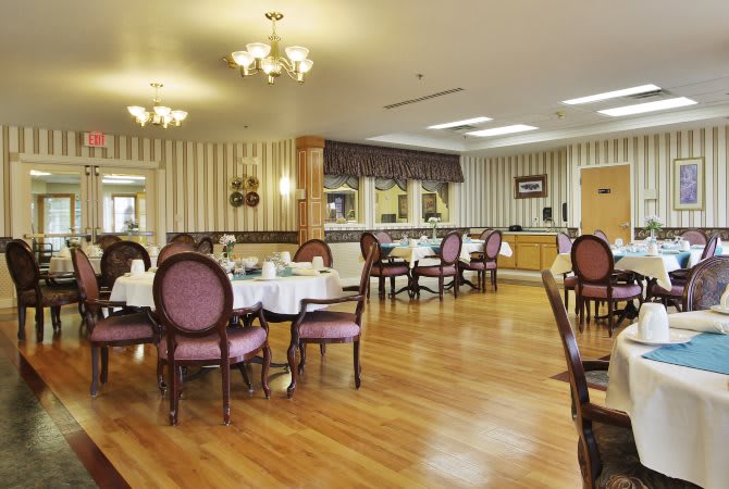 An elegantly decorated dining room with wooden floors and classical furniture.