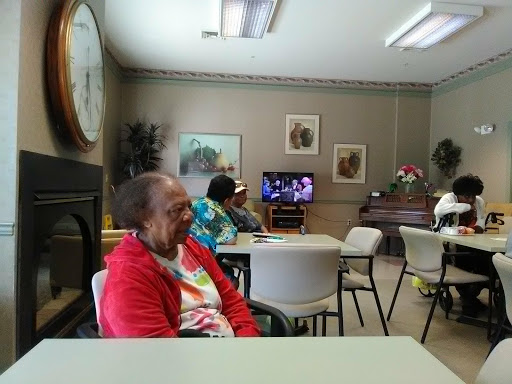 Elderly individuals gathered in a community center, enjoying various activities.
