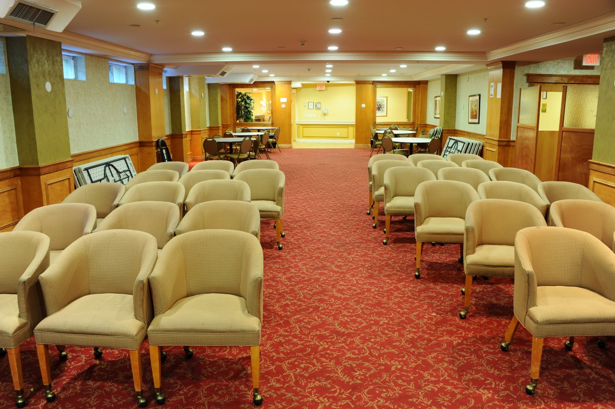 An empty conference room with rows of chairs arranged for a meeting.
