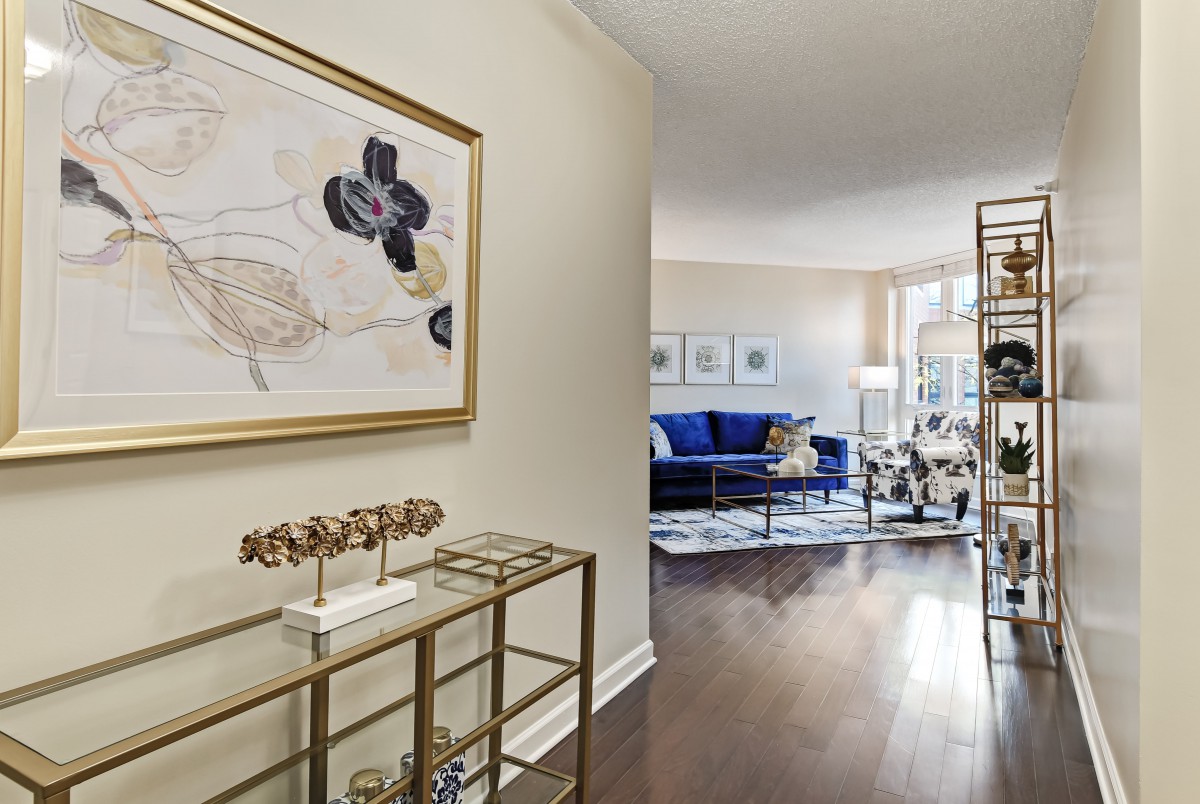 A modern living room with elegant decor, featuring a blue sofa and abstract artwork.