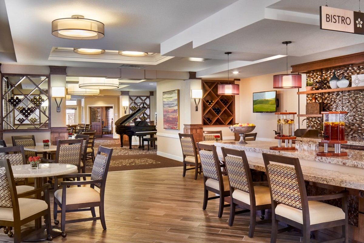 A modern and cozy dining room with elegant furniture and a grand piano in the corner.