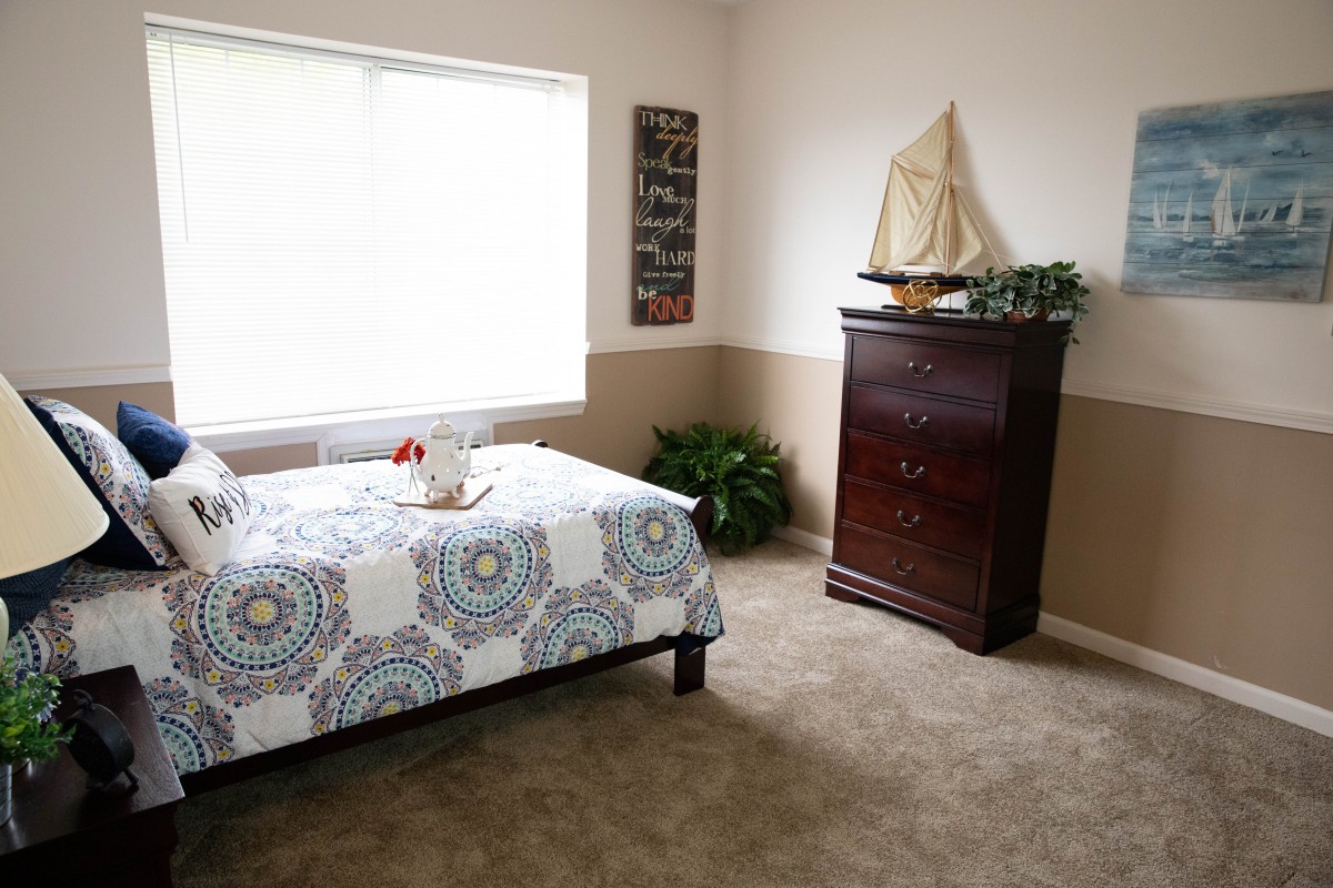 Cozy bedroom with nautical-themed decor and natural lighting.