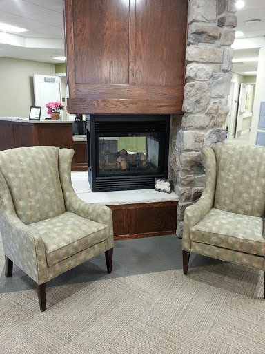 A cozy seating area featuring two patterned chairs beside a modern fireplace.