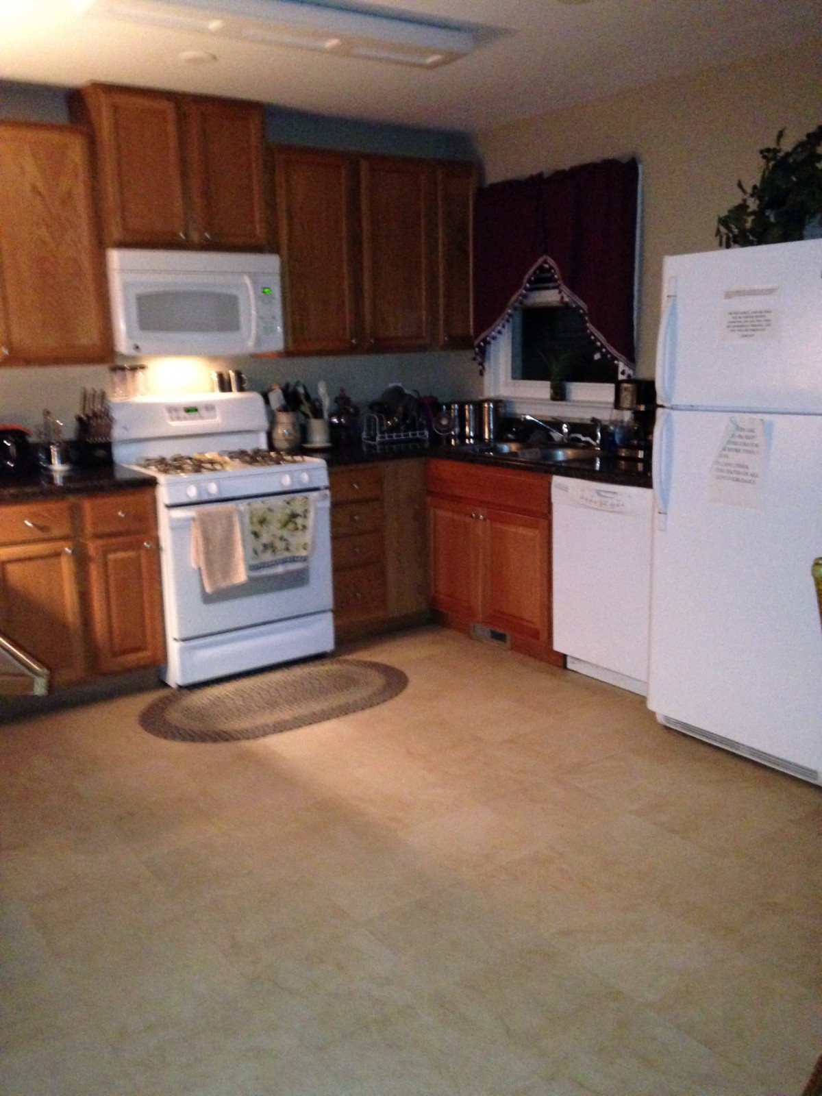 A cozy kitchen featuring modern appliances and wooden cabinets.