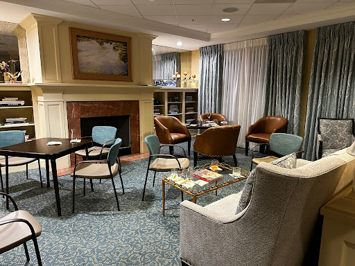 A cozy lounge area featuring comfortable seating, a fireplace, and inviting decor.