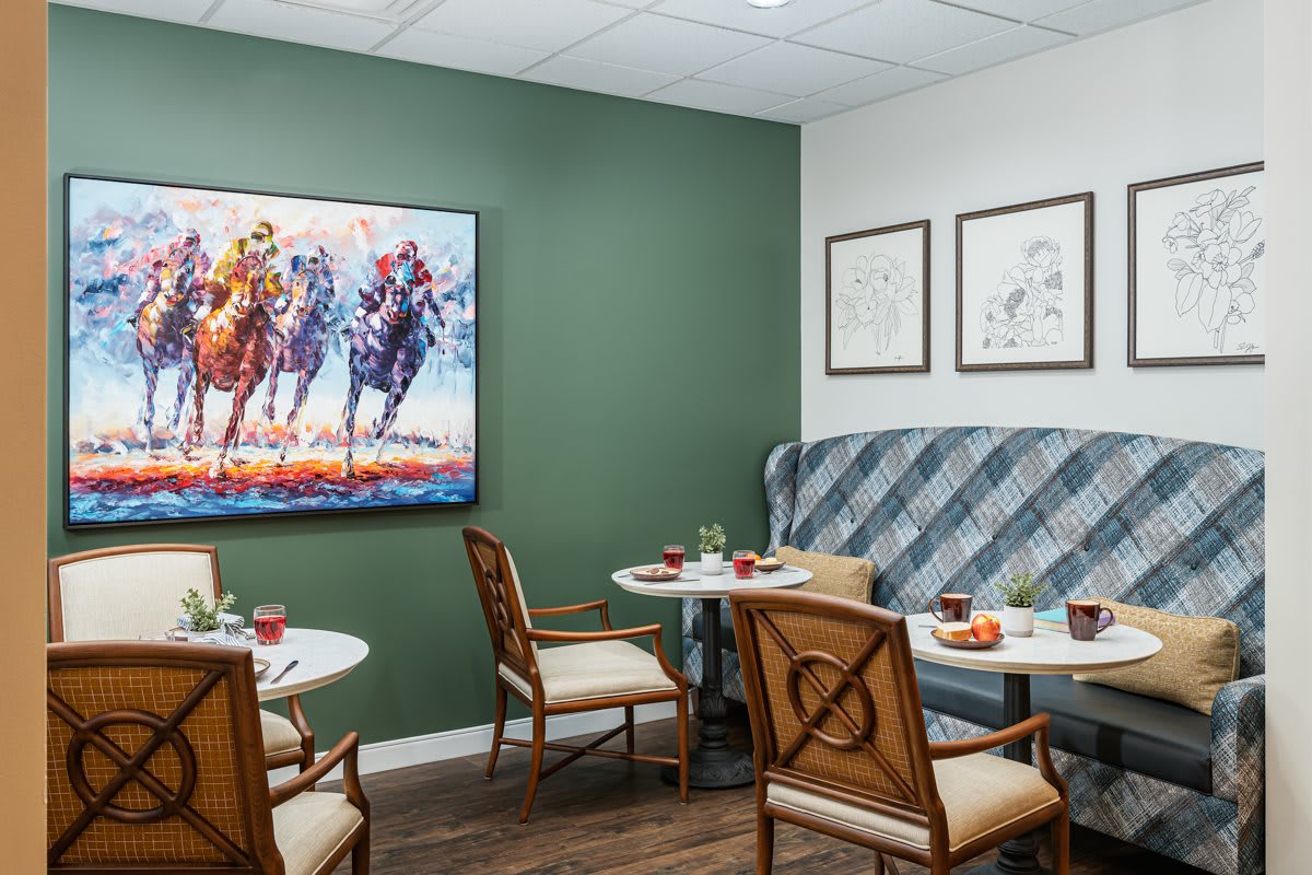 A cozy cafe interior with elegant seating, decorated walls, and artwork.