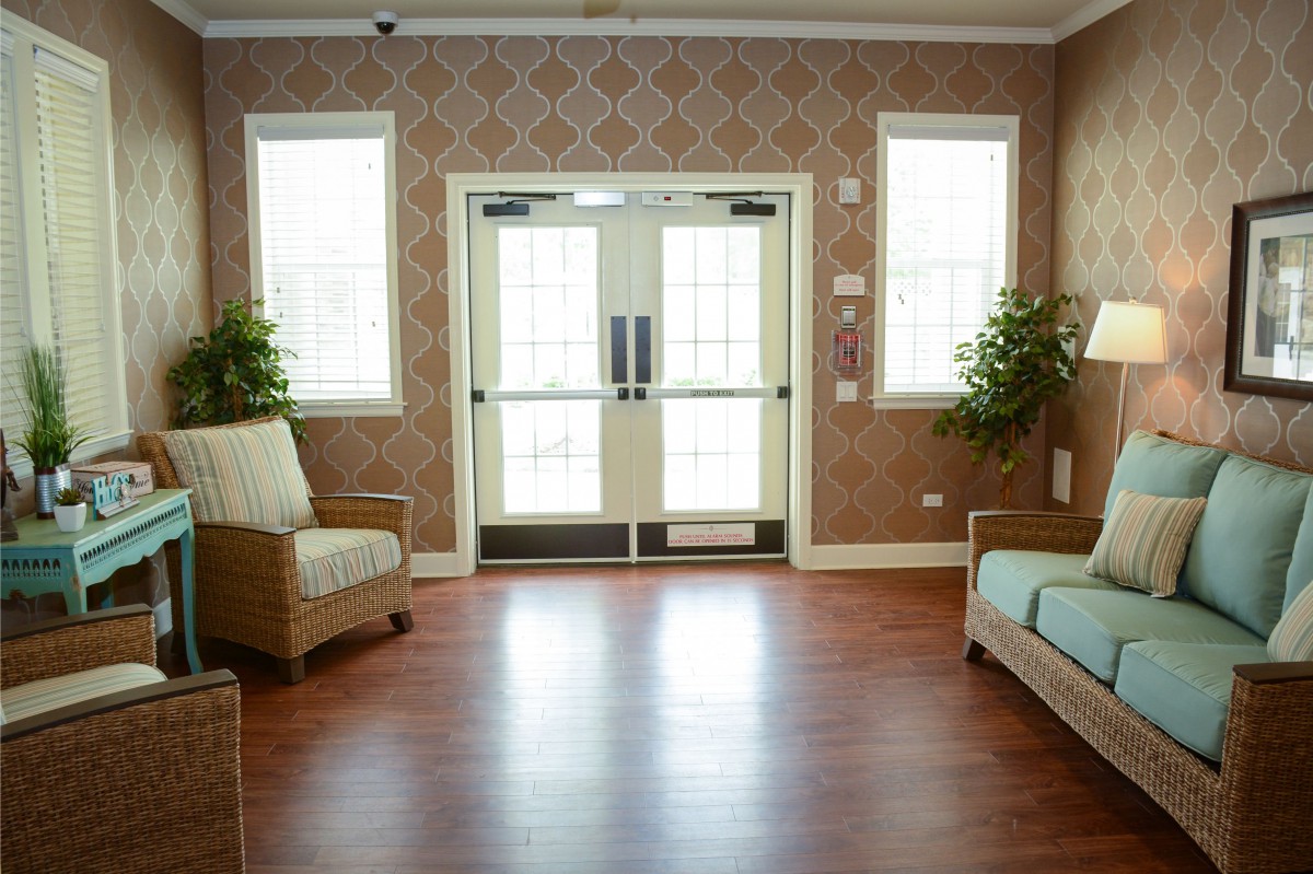 A cozy waiting area with sofas and plants near double doors.