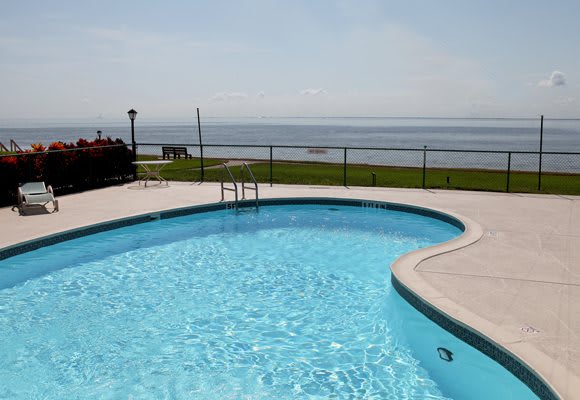 A swimming pool with an ocean view on a clear day.