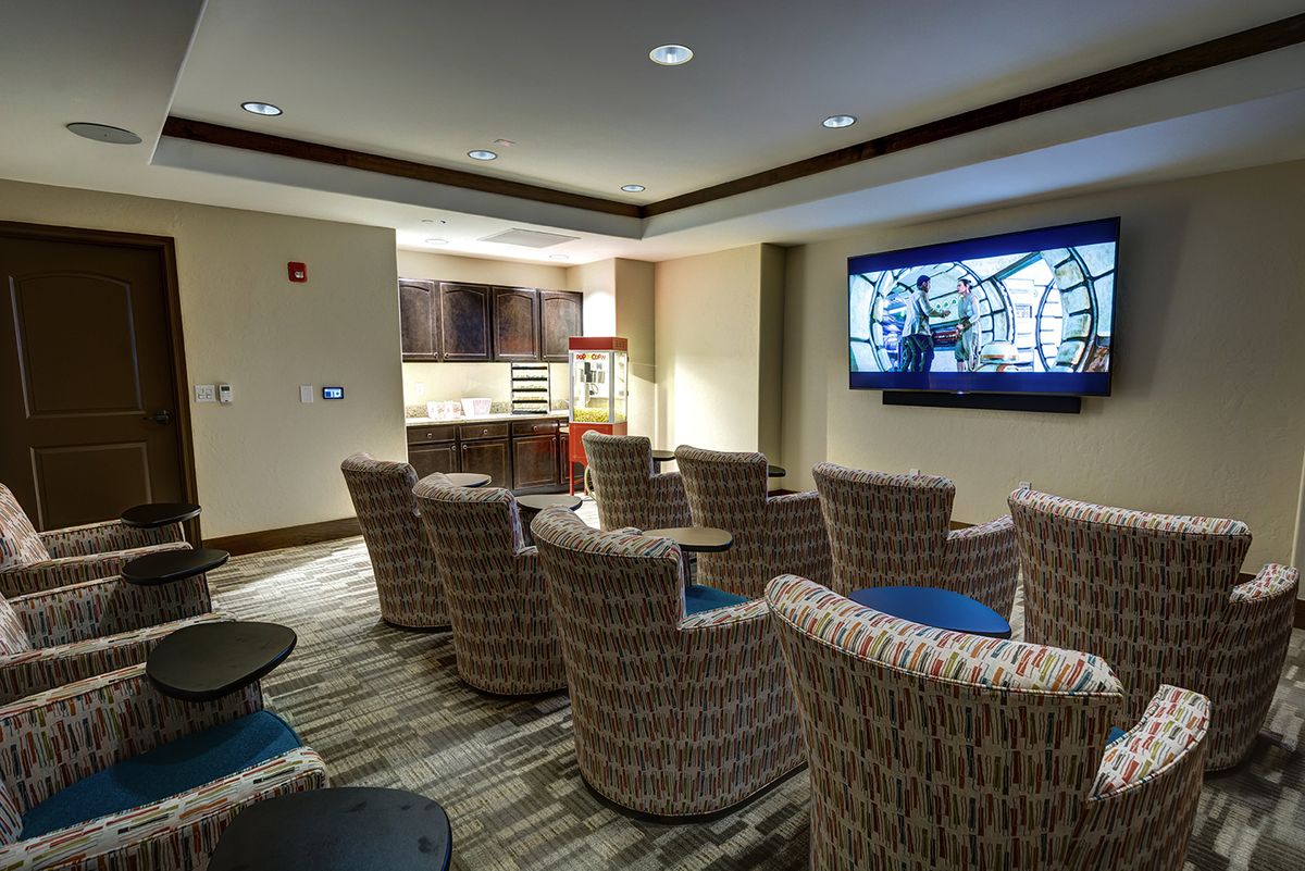 A cozy home theater room with comfortable seating and a large TV screen.