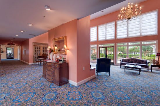 A spacious lobby with elegant furniture and a large chandelier.